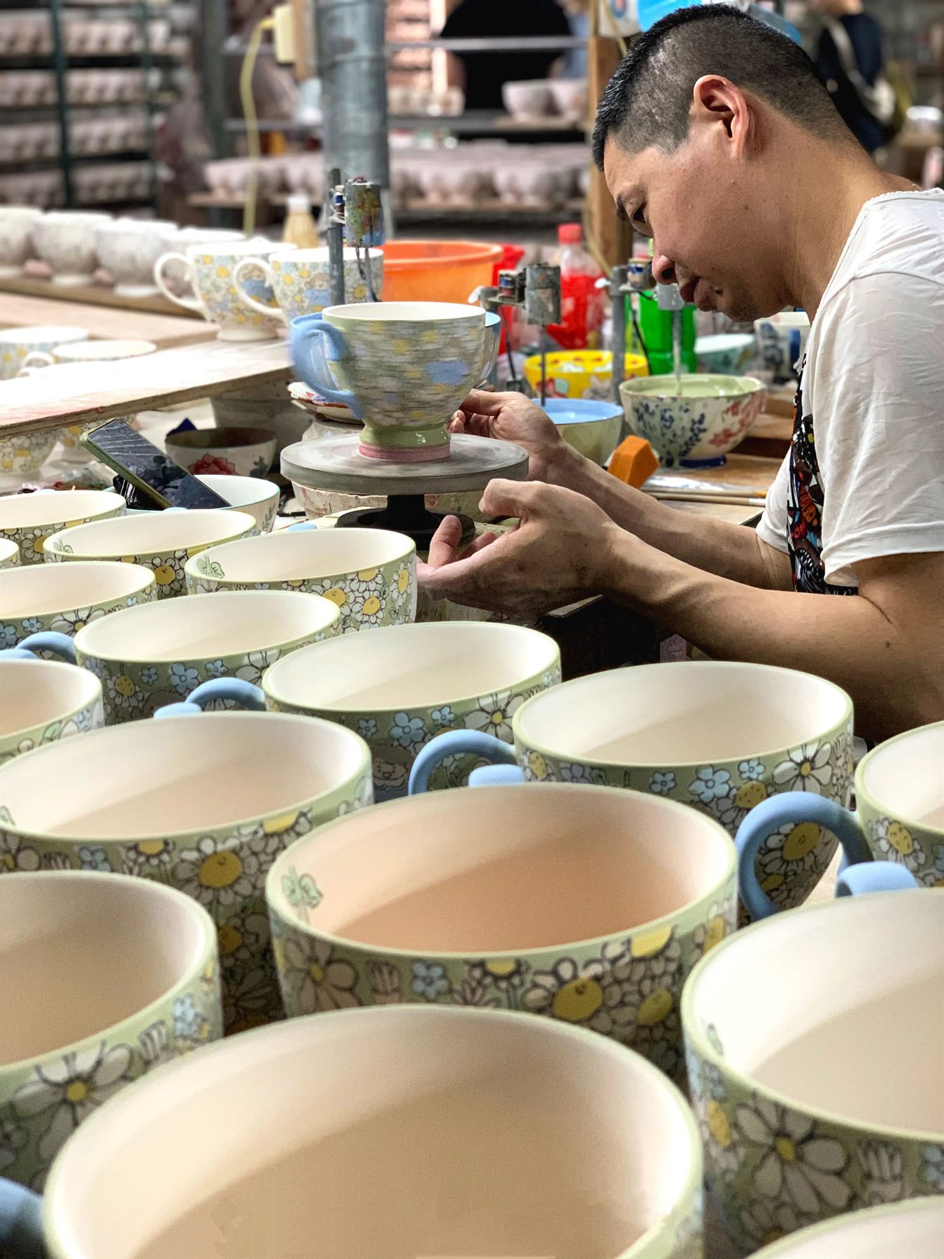 YONGXI craftsman working on ceramic cup finishing detail